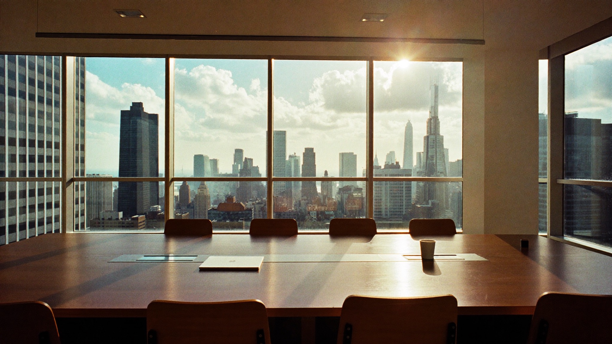 Leerer Besprechungsraum mit Blick auf eine Skyline im Morgenlicht